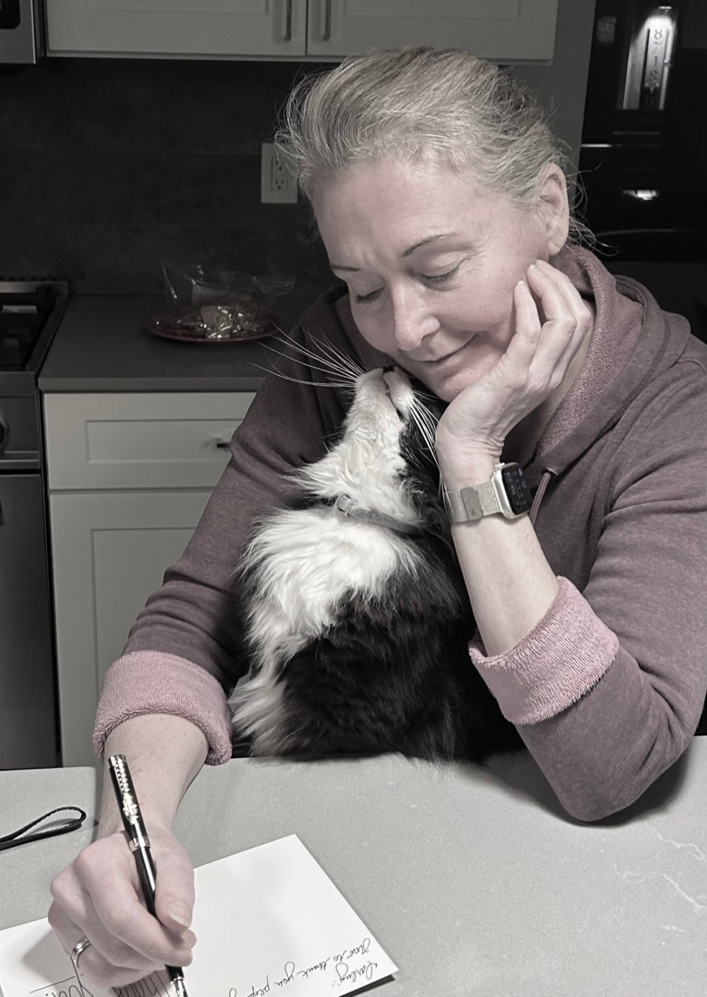 Lauren at home with a cat nuzzling her cheek